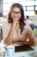 Businesswoman sitting at table and smiling in office