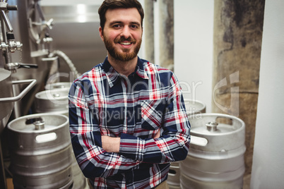 Smiling manufacturer standing in brewery