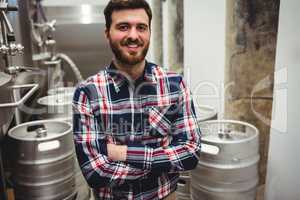 Smiling manufacturer standing in brewery