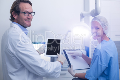 Dentist and dental assistant working on digital tablet