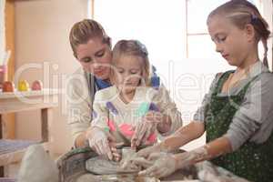 Female potter assisting girls