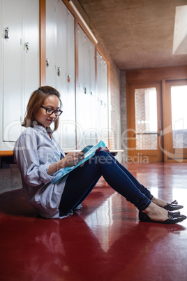Young woman using mobile phone in locker room
