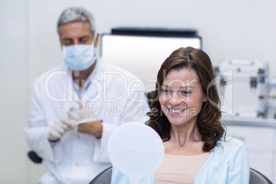 Patient checking her teeth in mirror