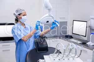 Dental assistant adjusting light