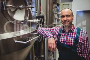 Smiling manufacturer standing at brewery