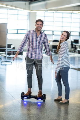 Graphic designer standing on hover board in office