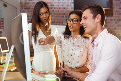 Businesswoman interacting with coworker while working on compute