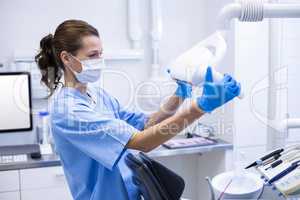 Dental assistant adjusting light