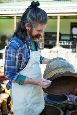 Male potter checking pot