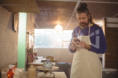 Male potter checking bowl