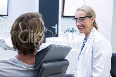 Female dentist interacting with male patient