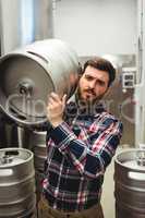 Male manufacturer carrying keg in brewery