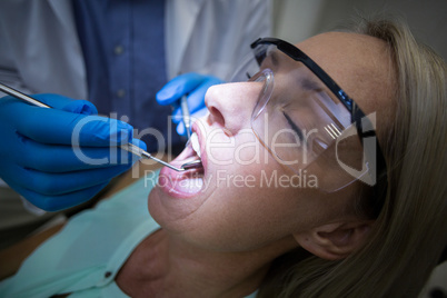 Dentist examining a woman with tools