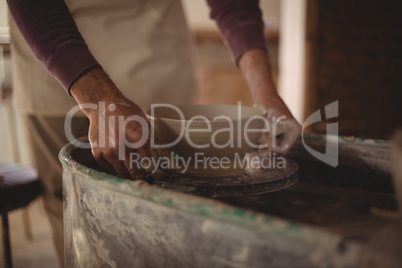 Male potter making bowl