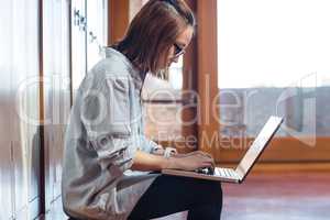 Young woman using laptop in locker room