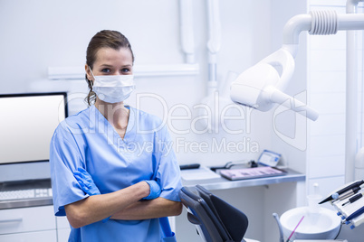 Smiling dental assistant standing with arms crossed