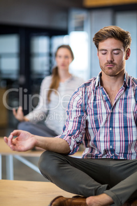 Business people performing yoga on table