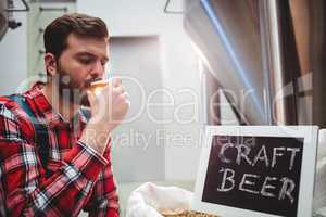 Manufacturer tasting beer at brewery