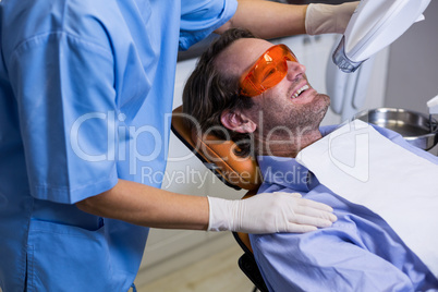 Dental assistant examining young patient mouth
