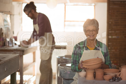 Female potter holding a earthenware pot