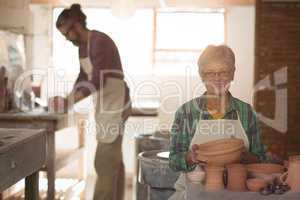 Female potter holding a earthenware pot