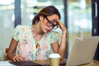 Frustrated female graphic designer looking at laptop