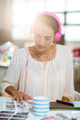 Graphic designer listening to music and looking at color swatch