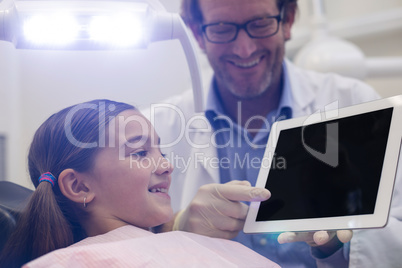 Dentist showing digital tablet to young patient