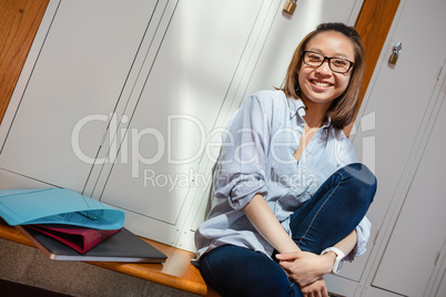 Happy young woman sitting in locker room