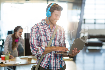 Smiling man with headphone using laptop