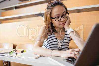 Young woman using laptop in classroom