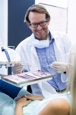 Male dentist holding tools