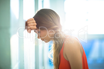 Tired businesswoman leaning on wall