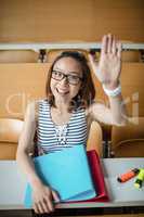 Young woman raising hand in classroom
