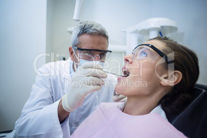 Dentist examining a woman with tools