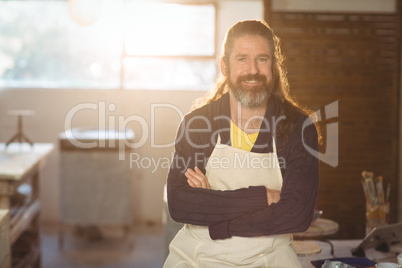 Portrait of male potter sitting on table