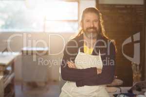 Portrait of male potter sitting on table