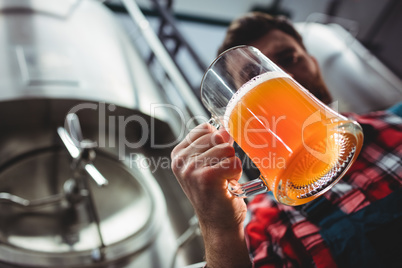 Manufacturer examining beer glass
