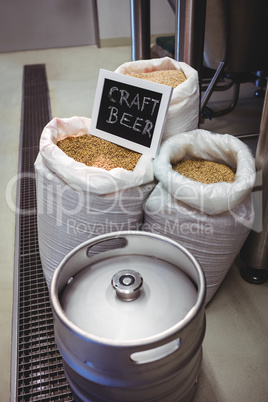 Barley in sack with keg at brewery