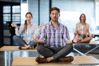 Business people performing yoga on table