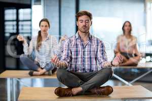 Business people performing yoga on table