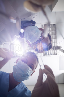 Dentist in surgical mask holding dental tools