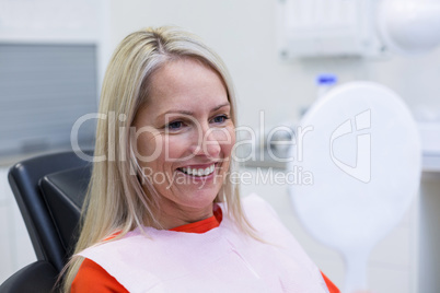 Patient checking her teeth in mirror