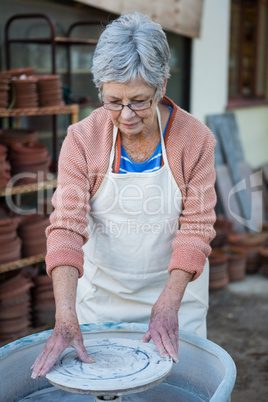 Female potter checking pottery wheel