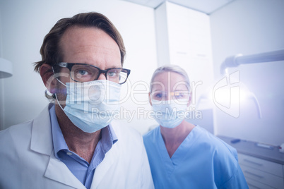 Portrait of dental assistant and dentist wearing surgical mask