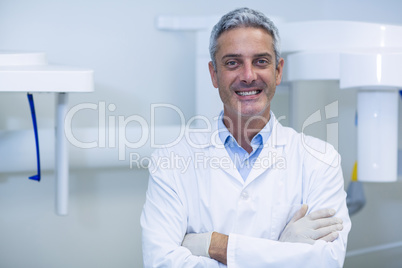 Smiling dentist standing in dental clinic