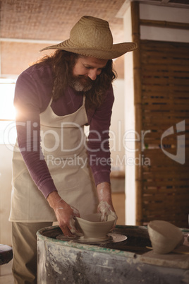 Male potter making bowl