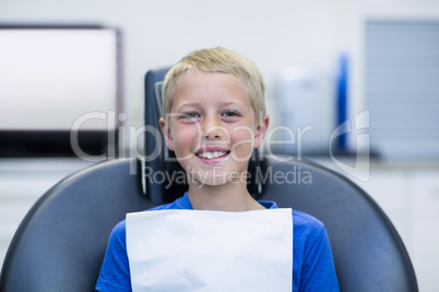 Smiling young patient sitting on dentist chair