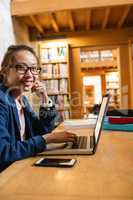 Young woman using laptop in library