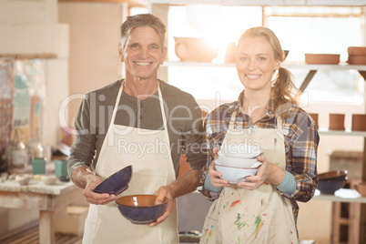 Potters holding pottery in workshop